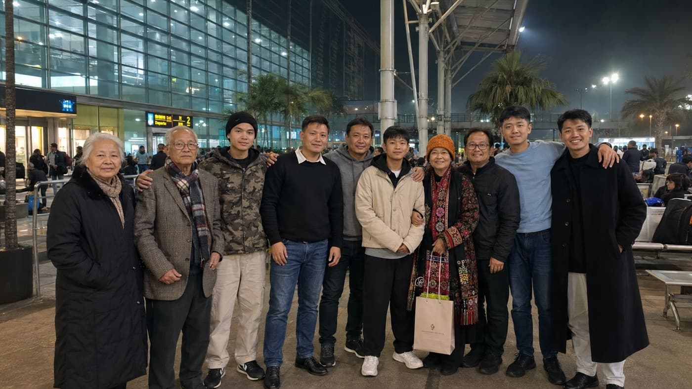 A large family group seeing a student off outside the airport terminal at night.